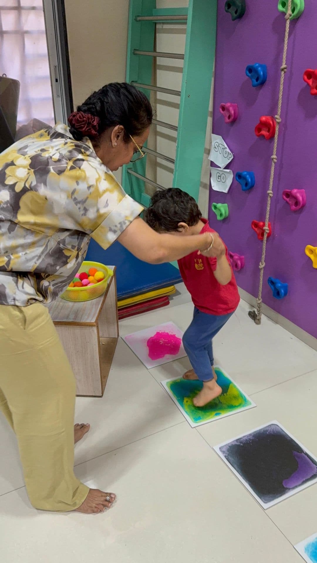 A child practising movement planning beside the climbing wall