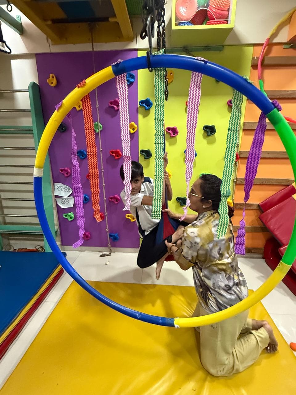 Therapist guiding a child through a supported swing activity